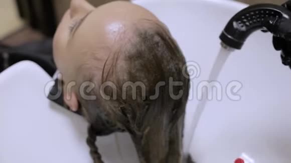 特写镜头发型师在做发型前洗女发型视频的预览图