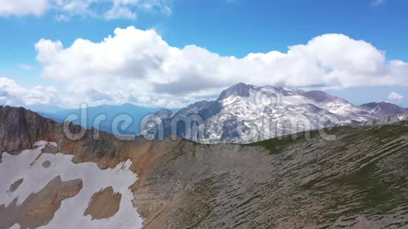 在岩石悬崖冰川和雪峰上拍摄的山脊的空中拍摄令人惊叹的山景视频的预览图