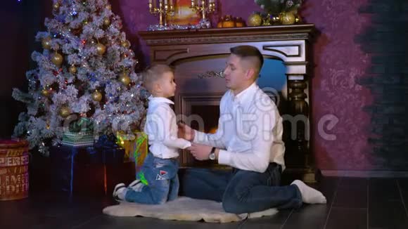 一个男人在圣诞庆典上教儿子一个复杂的问候手势视频的预览图