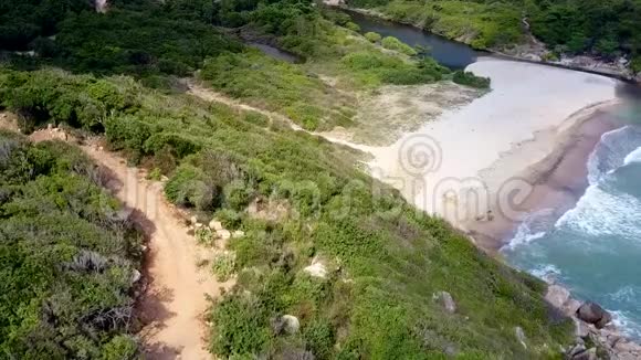 Drone悬挂在泻湖海滩上方的棕色道路上视频的预览图
