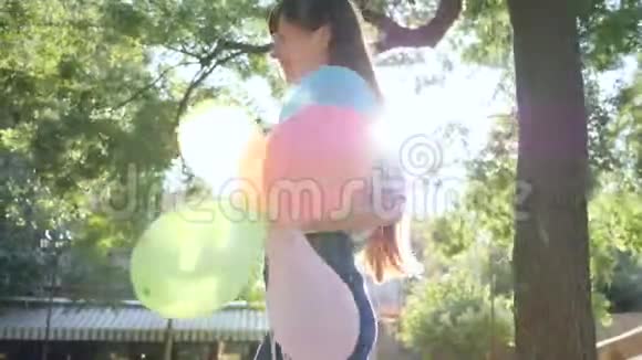 在阳光明媚的日子里快乐的女性用五颜六色的气球祝贺朋友在公园里生日快乐视频的预览图