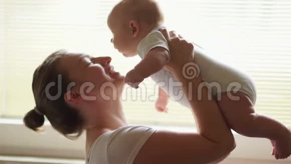 一位快乐的年轻母亲接她的孩子一个三个月大的孩子照顾婴儿长达一年母亲节视频的预览图