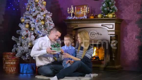 父母给他们的孩子一个小礼物在圣诞节晚上打开视频的预览图
