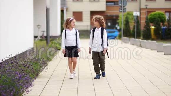 男孩护送女孩离开学校他用慈爱的目光看着她女孩微笑着拍拍他的肩膀视频的预览图