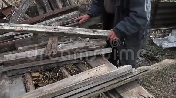一个非常老的人通过木板来修理小屋或点燃火战后的生活视频的预览图