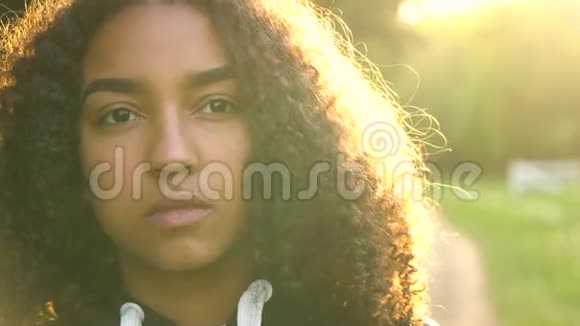 美国黑人少女少女女青年看着悲伤或沉思的背影夕阳西下视频的预览图