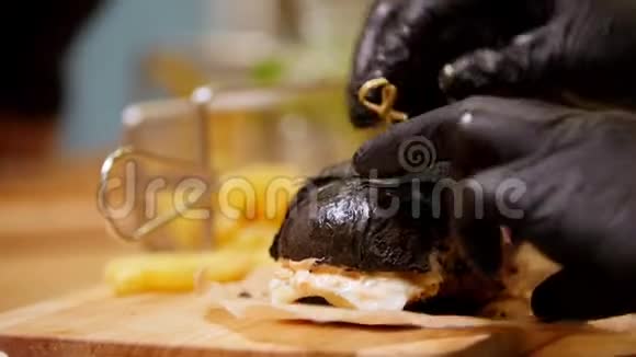 两个戴着黑手套的人吃黑汉堡视频的预览图