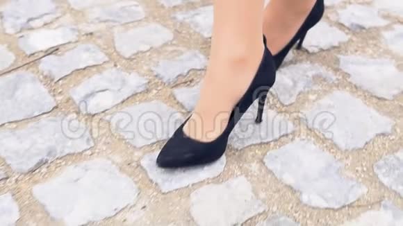在石路上穿黑鞋的女人的腿视频的预览图