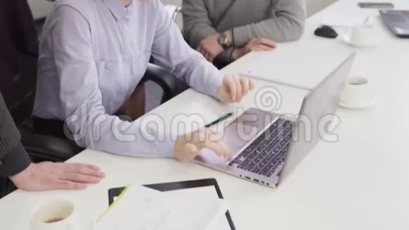 商务人士在工作场所的创意会议上观看笔记本电脑屏幕视频的预览图