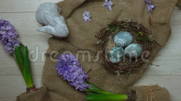 双手用彩蛋和鲜花装饰复活节彩巢视频的预览图