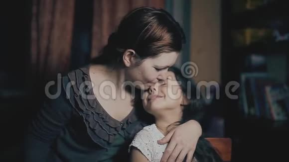 小女孩和成年女人拥抱照顾热爱家庭妈妈和女儿在房间里拥抱照顾视频的预览图