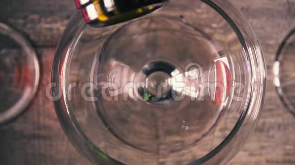 慢动作将白葡萄酒倒入有反光的玻璃杯中视频的预览图