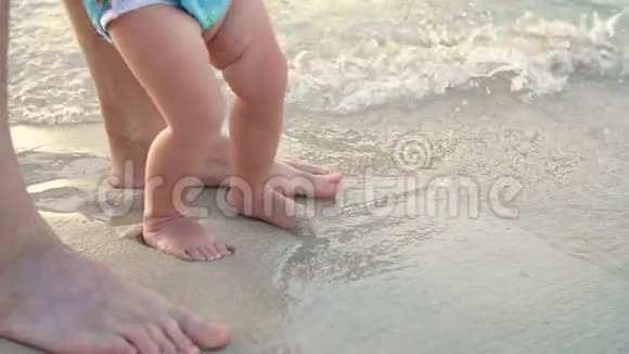 特写在潮湿的沙子上有男孩子脚一个波浪进来了海滨度假暑假视频的预览图