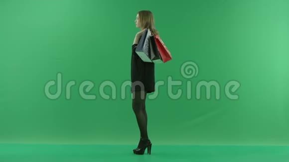 年轻女子购物后拿着袋子等待颜色钥匙绿色背景视频的预览图