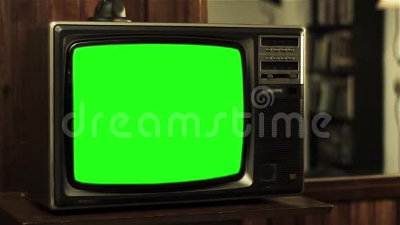 一个十几岁的男孩在电视旁用绿色屏幕的旧电话交谈视频的预览图