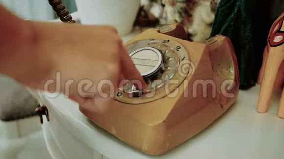 4K人们使用手指拨号复古旋转复古风格的电话复古色调的胶片染料旧的电信技术视频的预览图