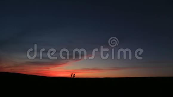 这对快乐的夫妇在手牵着手在鲜艳的夕阳下奔跑玩得很开心视频的预览图