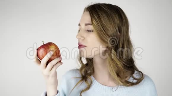 漂亮的头发女人咬着一个红苹果视频的预览图