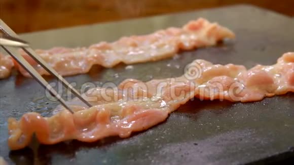 厨师用铁钳在烤架上烤咸肉视频的预览图