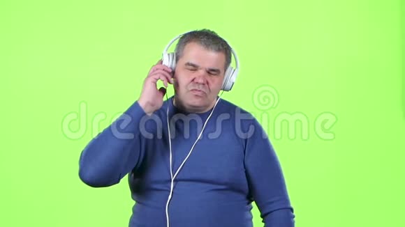 锰在耳机上听音乐绿色屏幕慢动作视频的预览图