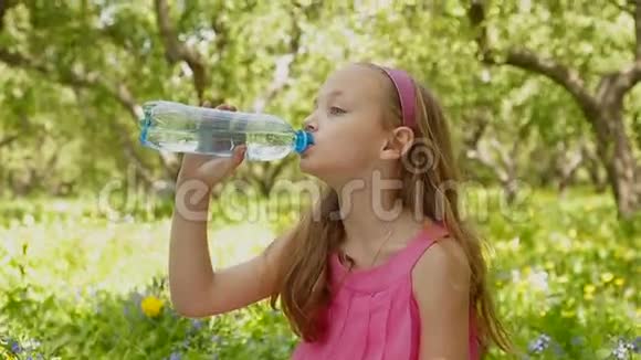 小女孩的脸在夏日绿园喝水瓶视频的预览图