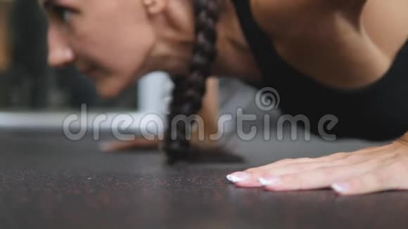 肌肉发达的年轻女人在健身房做俯卧撑运动女孩在室内锻炼锻炼健康的生活方式关门视频的预览图