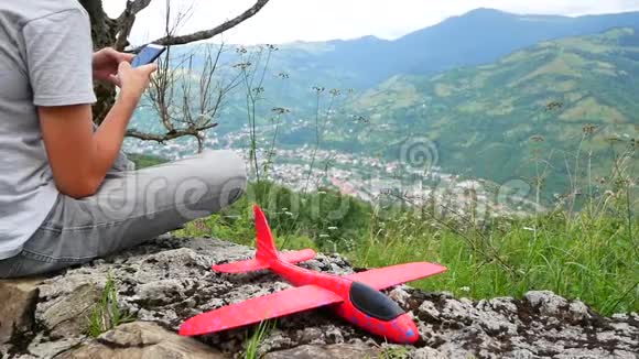 白人男孩玩模型飞机一个在田野里坐木飞机的孩子的肖像大自然中的男孩视频的预览图
