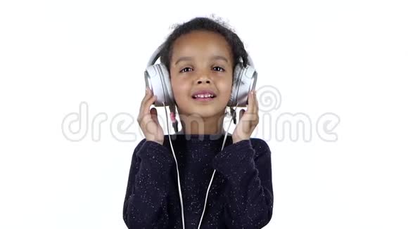 非裔美国人的孩子听着耳机里的音乐白色背景慢动作视频的预览图