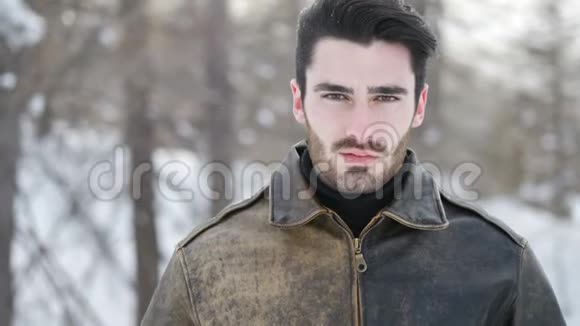 在白雪皑皑的高山上英俊自信的男人视频的预览图