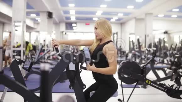 穿黑色运动服的年轻女性健美运动员在健身房锻炼建立强壮的核心和手臂肌肉视频的预览图