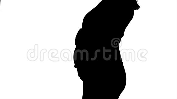 孕妇站着抚摸她的胃剪影白色背景慢动作关门视频的预览图