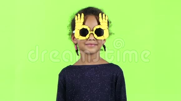 一个戴着滑稽眼镜跳舞的非裔美国女孩的孩子绿色屏幕慢动作视频的预览图