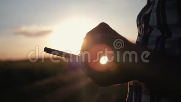 日落时分一名男子正戴着一顶帽子正在制作一部智能手机与客户的沟通现代商业视频的预览图