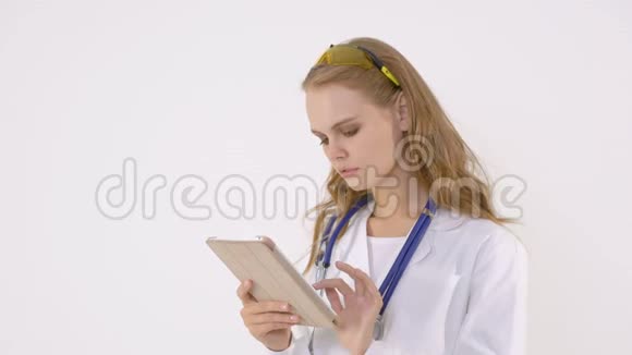 快乐女医生在白色背景下使用平板电脑视频的预览图