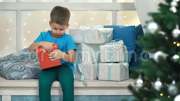 可爱的小男孩打开盒子圣诞礼物视频的预览图