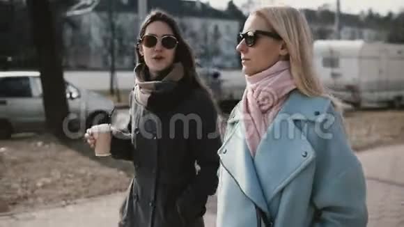 两个白种人女朋友散步聊天穿时髦外套的女士在街上八卦女人享受亲密的时光视频的预览图