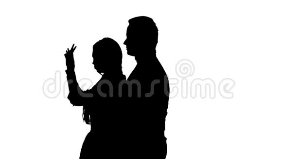 相爱的夫妇亲吻和跳舞在一起剪影白色背景慢动作关门视频的预览图