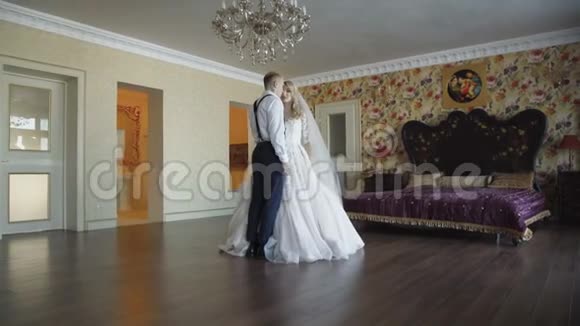 豪华卧室里华丽的新婚夫妇带着微笑亲吻视频的预览图