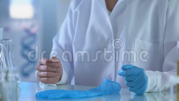 女科学家戴上手套准备实验室实验工作视频的预览图