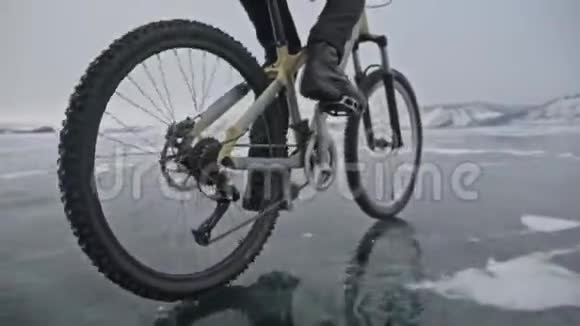 对轮胎的看法拍摄180fps人在冰上骑自行车骑自行车的人在镜头前割伤了冰的碎片视频的预览图