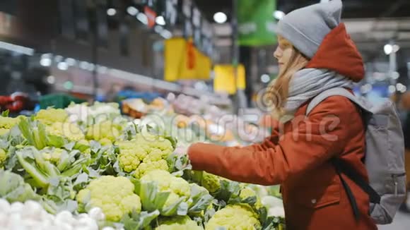 不错的运动女士正在超市里挑选蔬菜摊上的西兰花视频的预览图