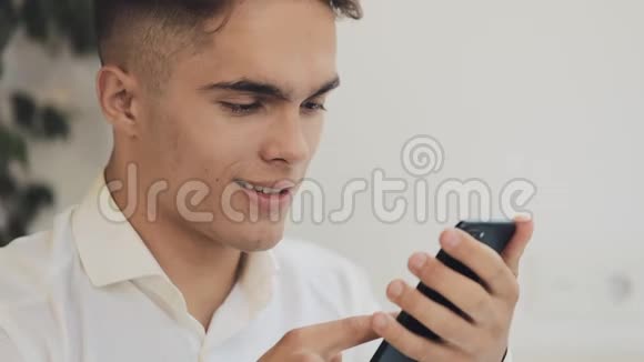 年轻的快乐商人在咖啡馆里使用智能手机斯特迪卡姆射击自由交流IT成功人士视频的预览图