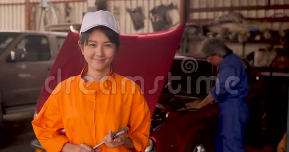 一位年轻漂亮的汽车修理工在汽车车间的肖像视频的预览图