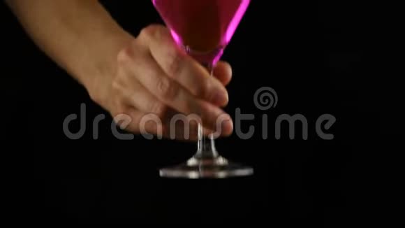 女人的手在黑暗中准备一杯带柠檬的粉红色鸡尾酒派对概念慢动作视频的预览图