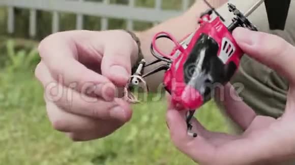 盖伊手拿着红色的纳米玩具直升机把结婚戒指戴在雪橇上视频的预览图