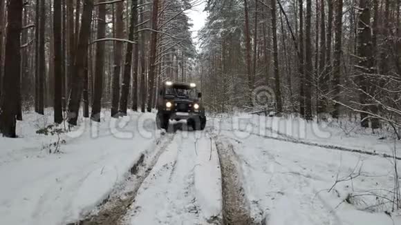 驾驶越野车6x6行驶在冬季森林的越野车前景右视频的预览图