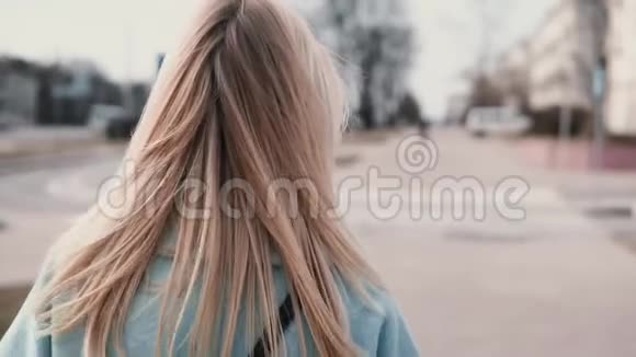 后景女性留着长长的金发女商人穿着蓝色外套留着美丽的长发慢动作视频的预览图