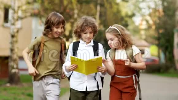 两个男孩和一个女孩三个学童在放学路上热烈讨论这本书回到过去视频的预览图