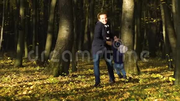 快乐的年轻母亲在秋天公园拥抱她的小儿子的慢镜头画像视频的预览图