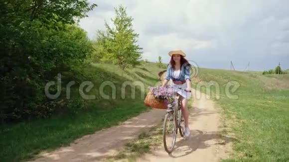 戴着帽子骑着自行车在大自然中旅行的女人视频的预览图
